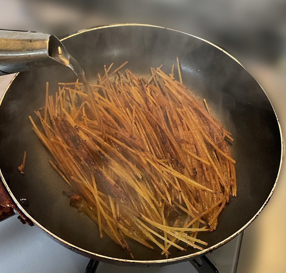 イイ感じのお焦げが出来たところにやかんから熱湯を注いでいる様子