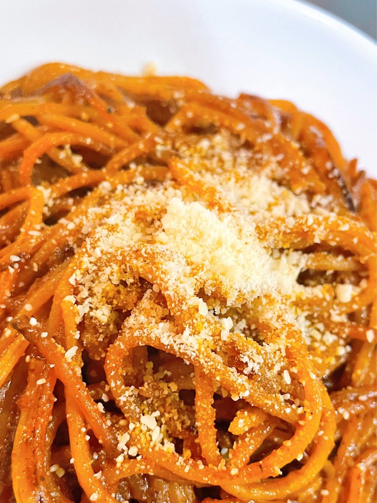 出来上がったパスを皿に盛り、上から粉チーズをまぶした様子