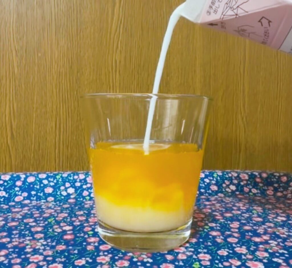 好烏龍(ハオウーロン)が入ったグラスに、牛乳を注いでいる様子