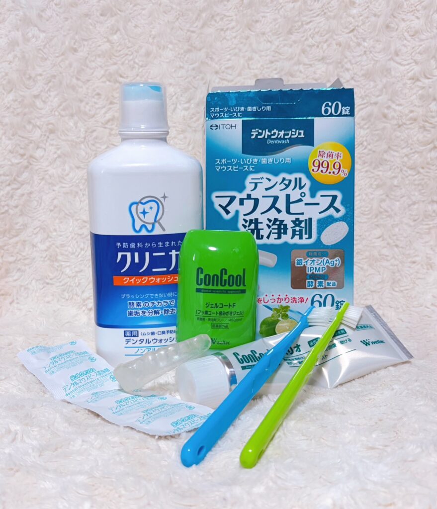 まる美が実際に使っている、コンクールジェルコートとリペリオ、マウスピース洗浄剤、クリニカのマウスウォッシュ、歯ブラシを並べて撮った写真。