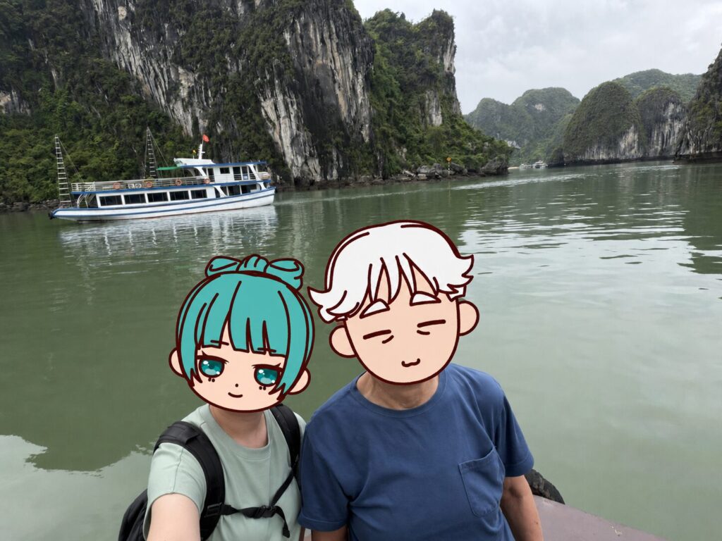 ハロン湾のクルーズ船で湾を背景に2ショットで撮影しているおじいちゃんとまる美。
