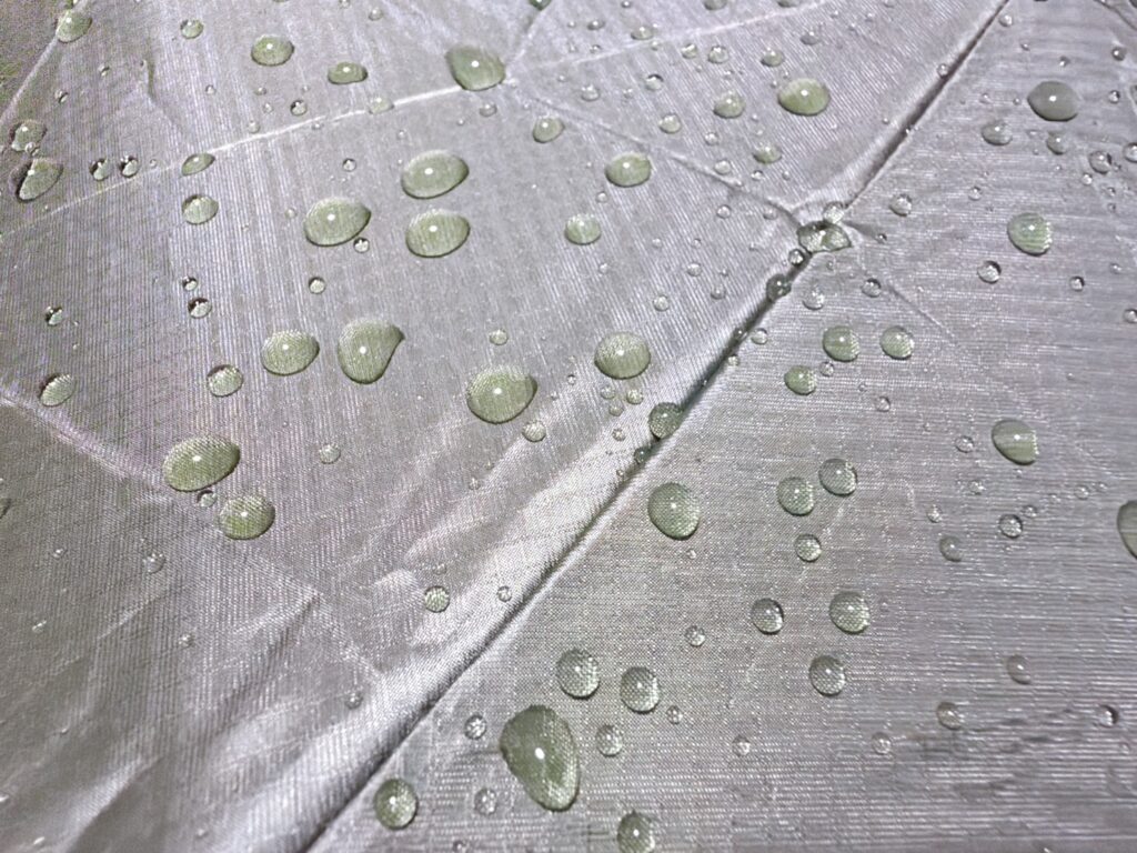 カーキ色のpentagon72の生地の上で、水玉がコロコロと転がっている撥水の様子