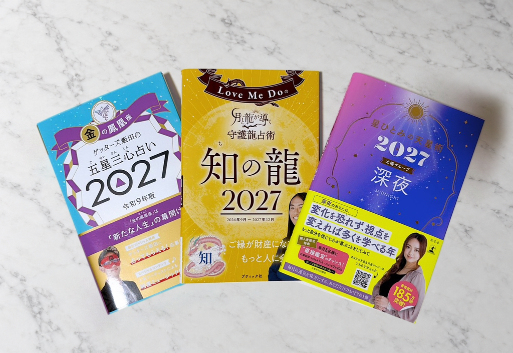 白い大理石の上に並べた、ゲッターズ飯田・Love Me Do・星ひとみの2027年版の占い本3冊